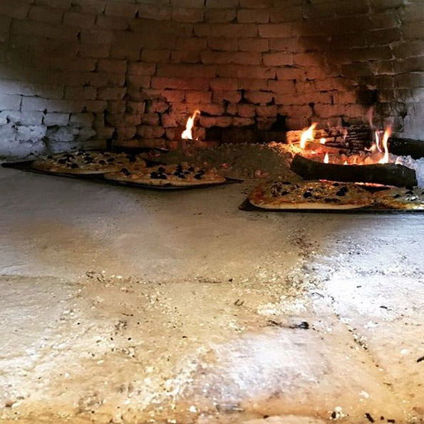 Cuisson des pizzas dans le four à pain du Domaine de l'Astic