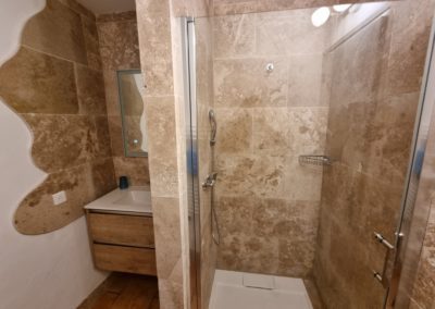 Salle de bain en marbre du gîte l'olivier du domaine de l'Astic avec douche et lavabo